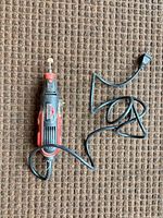 Full view of rotary tool with cord and plug laid out on carpet
