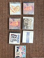 Seven of the eight CDs laid out on carpet