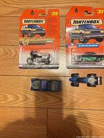 Overview showing two carded Matchbox vehicles and two loose vehicles