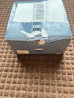 Exterior of original blue-grey No!No! box showing shipping label residue and torn flap