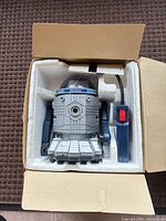 Robot and remote seated in styrofoam inside box