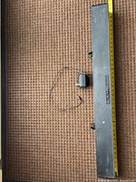 Full view of RCA sound bar with power adapter and tape measure showing length