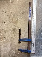 Full view of clamp alongside ruler showing 24 in length