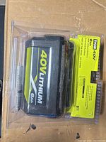Front view of sealed Ryobi 40V 6Ah battery in clear plastic packaging