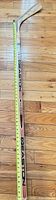 Full view of hockey stick with tape measure indicating length