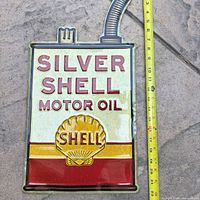 Full view of Shell Silver Shell Motor Oil sign with tape measure indicating height