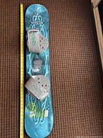 Full length view of E3 snowboard with bindings and tape measure showing ~110 cm