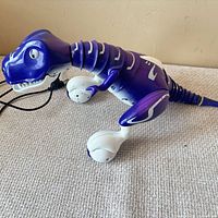 Side view of purple and white robotic dinosaur on tabletop
