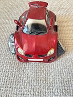 Front view of red Street Machines toy car showing grille, headlights, oversized wheels