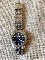 Front view of watch showing blue dial, bezel, bracelet