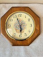 Front view showing full clock face and wood octagon frame