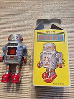 Front view of robot toy beside box