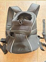 Front view of Woyyho dog carrier backpack showing mesh front, drawstring opening and straps