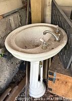Full view of pedestal sink showing basin, faucet and pedestal