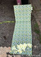 Unfolded chair showing full length cushion and backrest, green polka dot pattern fabric