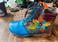 Side view of right boot showing colours, appliqué and laces