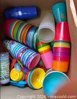 Box containing stacked plastic tumblers, character cups and plastic spoons