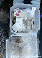 Top view of two bins showing buttons on cards and loose buttons in bags