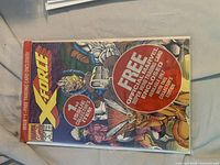 Front of sealed X-Force Issue 1 comic showing cover and promo circle