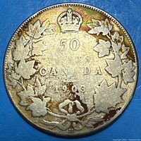 Reverse of 1903 Canada 50¢ coin showing denomination, maple wreath, crown, H mintmark and toning