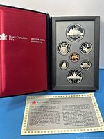 Open presentation case showing all seven encapsulated coins alongside certificate