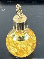 Front view of glass bottle showing gold flakes and label