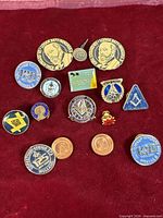 All 15 Freemason and DeMolay pins arranged on red background