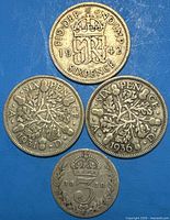Obverse and reverse views of four British silver coins dated 1918, 1931, 1936, 1942