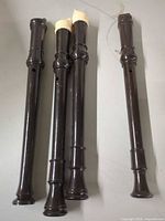 Four brown plastic recorders laid side-by-side