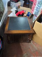 Top and sides of square wood end table showing black inlay panel