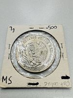 Reverse of 1947 Mexico 1 Peso silver coin showing eagle with snake and inscriptions, in cardboard flip