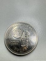 Obverse with curling broom, stone and event text
