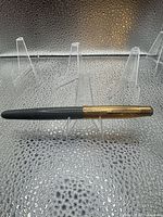 Full view of closed fountain pen showing gold cap and black barrel