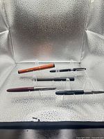 All four fountain pens on clear stands