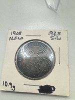 Reverse of 1908 Newfoundland 50 cents coin in holder, annotations show .925 silver and 10.9 g