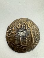 obverse of irregular 8 Reales cob coin with shield, pillars, and visible 8