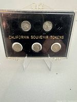 front view of display case showing six tokens and gold lettering