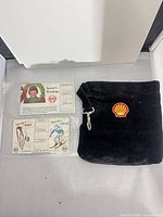Overall view of both calendar cards in sleeves and black velvet Shell pouch