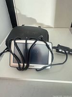 Front view of TomTom GPS with coiled charger cable and carry case
