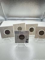 Group shot of five coins in holders