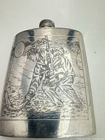 Front of pewter flask showing engraved standing fisherman scene