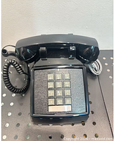 Front view of black Cortelco desk phone with keypad