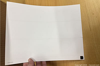 Close view of single cardstock sheet showing perforation layout