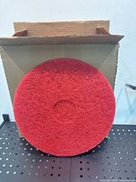 front view of a single red buffing pad against box