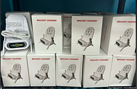 Stack of individually boxed bracket chargers plus one charger unboxed