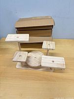 Assembled wooden display stand in front of three sealed boxes