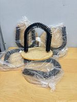 Five identical cat scratcher arch toys, one unwrapped for display, four still bagged