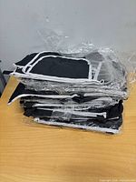 Stack of packaged black trunk organizers on table