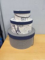 Three stacked round fabric hat boxes showing sizes and patterns