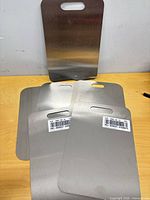 Five medium stainless boards stacked with barcodes and one large board behind